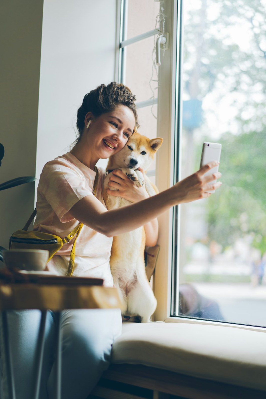 Mujer tomando una fotografía a su perro con luz natural